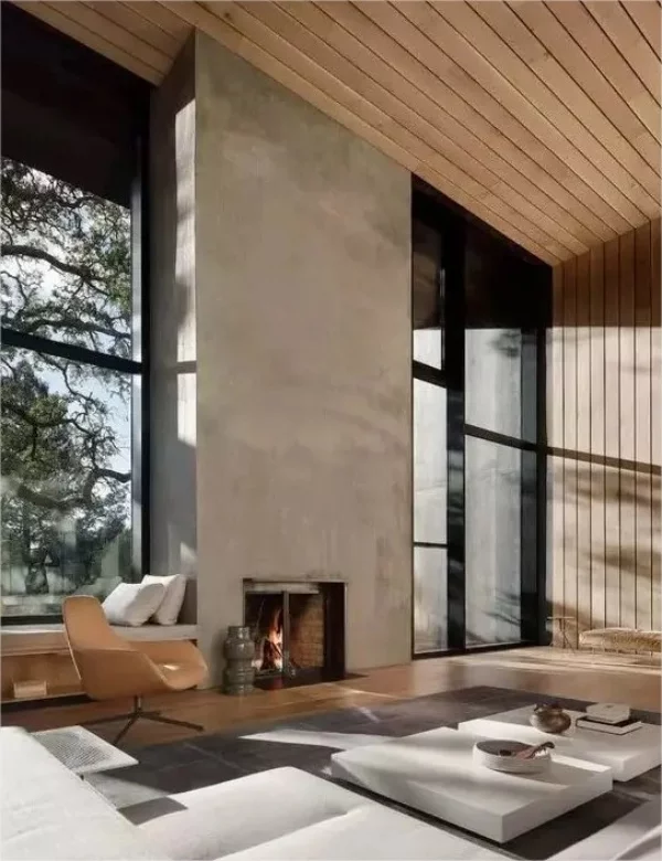 Minimalistischer Kamin Kaminwand aus beton Kombination mit Holzvertaefelung im Raum