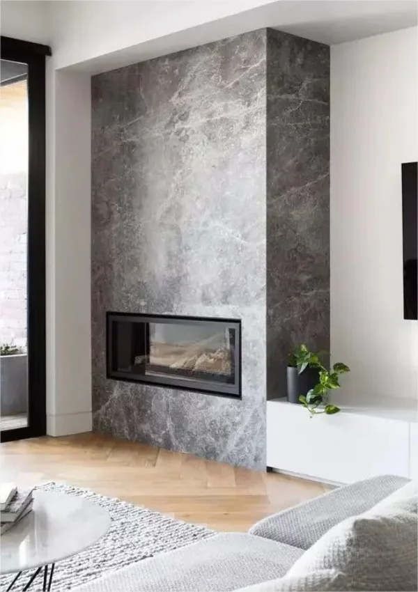 Minimalistischer Kamin ganze Wand in grauem Marmor verkleidet schoenes Aussehen