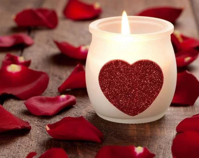 Last Minute Valentinstag Deko Teelicht Glas mit rotem Herzen geschmueckt rote Bluetenblaetter