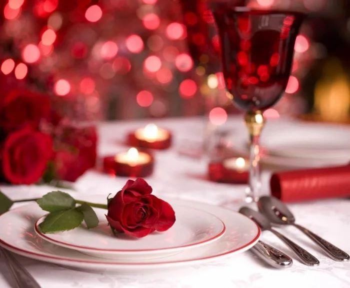 Romantische Tischdeko am Valentinstag rote Rosen weisses Porzellan Weinglas Teelichter