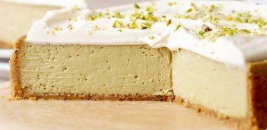 Käsekuchen mit einer Sahnenschicht und Nüssen