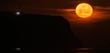 ein großer orangefarbener Mond am nächtlichen Himmel 