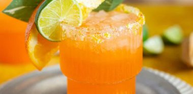 Orangensaft mit Limettenscheiben und Minzblättern garniert